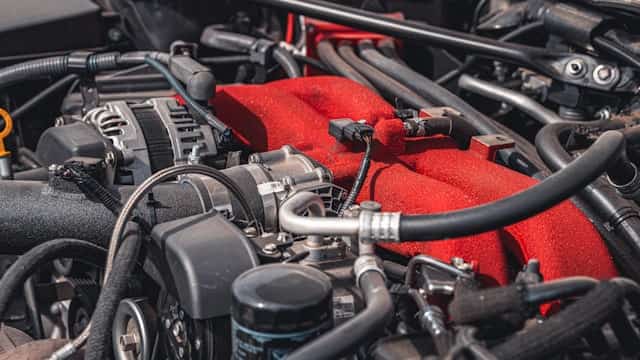 Car engine bay with red intake and wiring