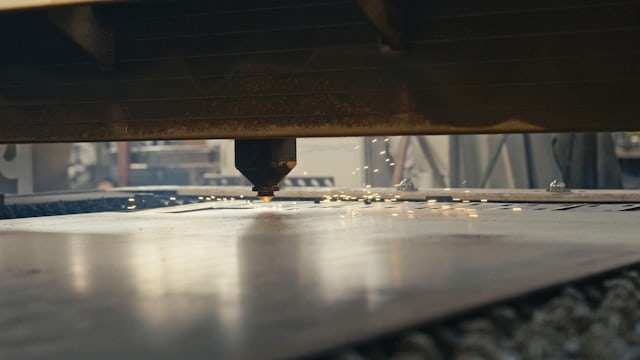Laser cutting head working across a metal sheet