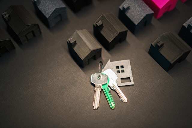 House-shaped keyring and keys among miniature houses