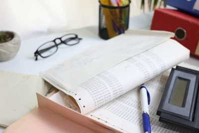 Calculator, ledger, and stationery on an office desk