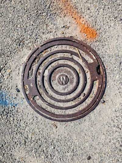 Cast-iron drainage cover set into a paved surface