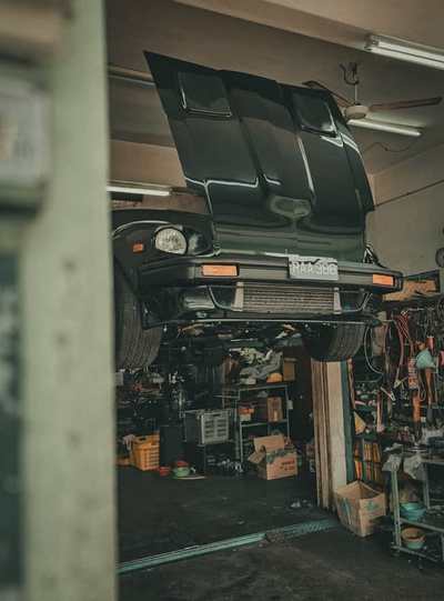 Dark car raised above equipment in a garage workshop