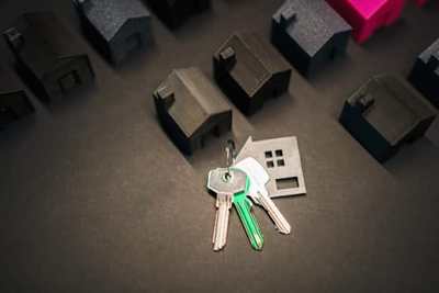 House model and keys arranged on a dark table