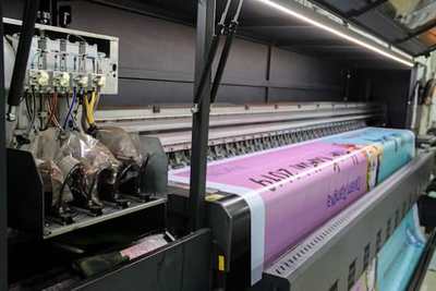 Commercial printer producing a roll of colourful paper