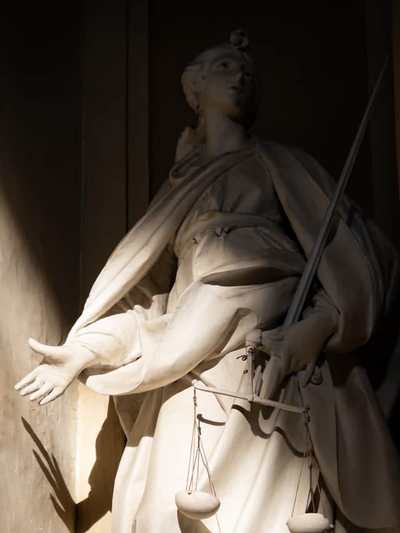 Scales of justice statue lit in a legal display